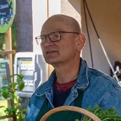 Bénévole de l'association au stand des légumes et herbes bio